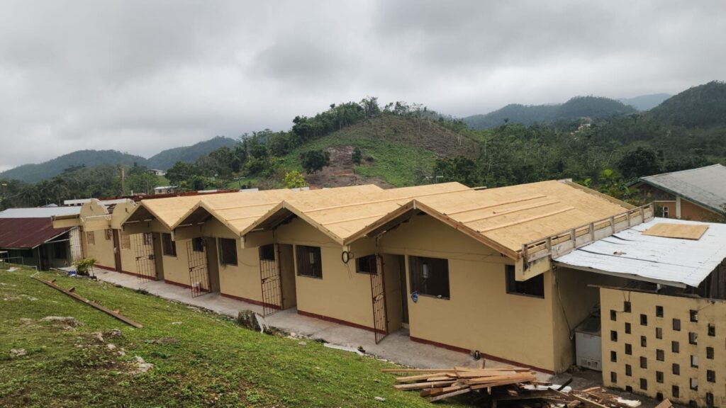 Roof sheathing on a row of residential units with hills behind