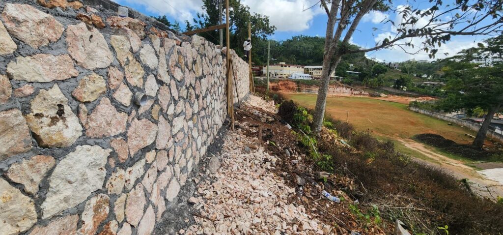 Dry stone faced retaining wall built along a sloping site